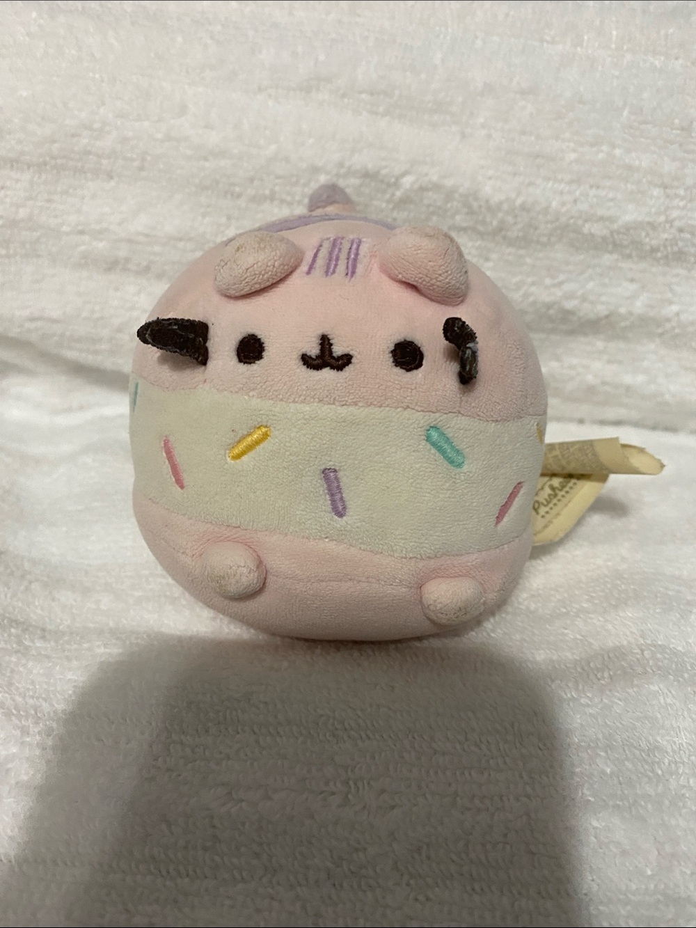 This GUND plush toy features Pusheen reimagined as a pink and white ice cream sp